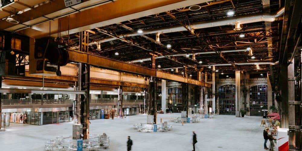 Interior of a large industrial warehouse with steel beams and an overhead crane
