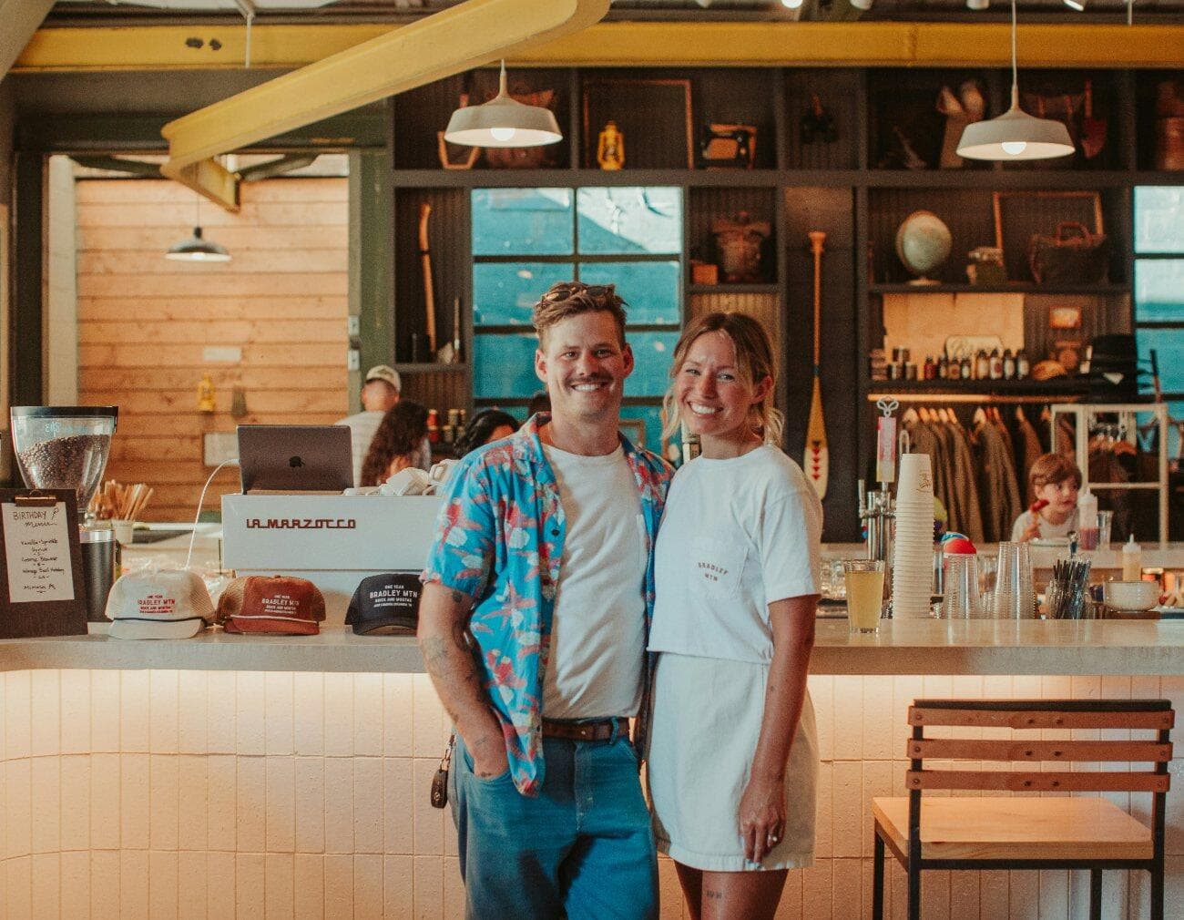 Two café owners behind the counter of their business