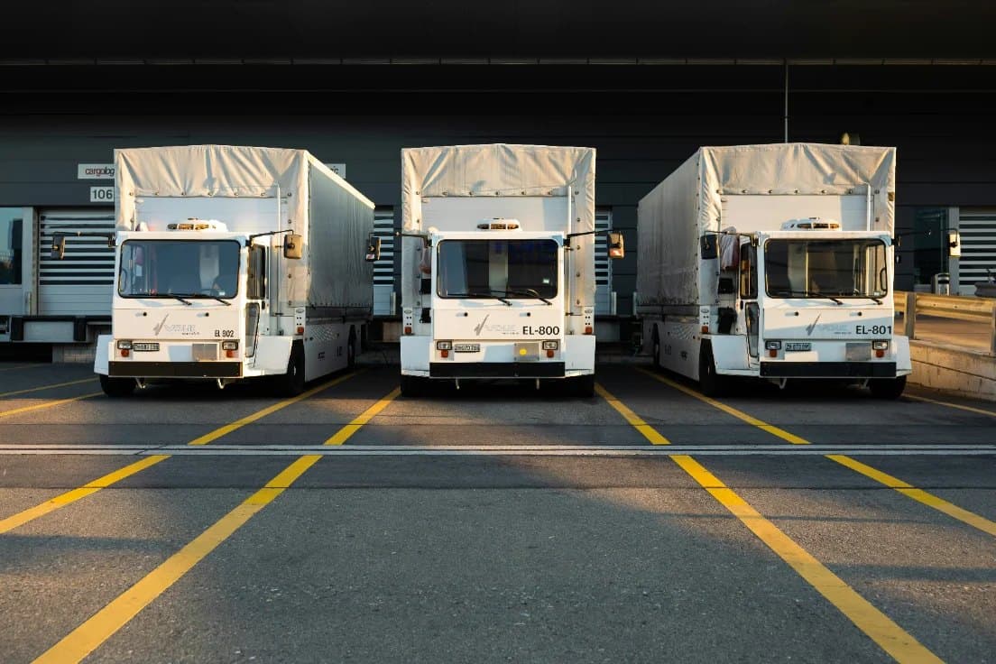Three delivery trucks backed into loading bays at a distribution centre